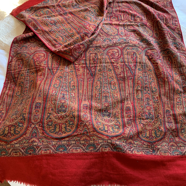 Photo of a red and orange sari with sophisticated pattern and red band around the edges